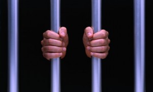 Man's hands on prison bars